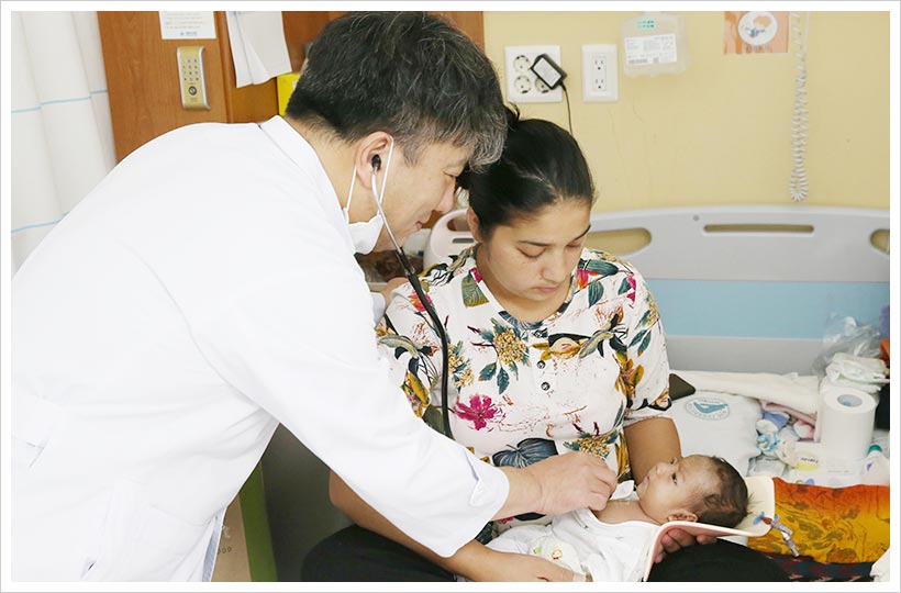 수술 후 건강하게 회복 중인 쓰리전을 서울아산병원 소아심장외과 윤태진 교수가 살펴보고 있다.