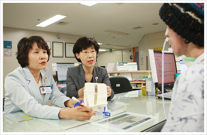 서울아산병원 김이영(우), 조정원(좌) 간호사가 위 수술 후 위액과 가스 제거 가 필요한 환자에게 개발된 배액주머니에 대해 설명하고 있다.